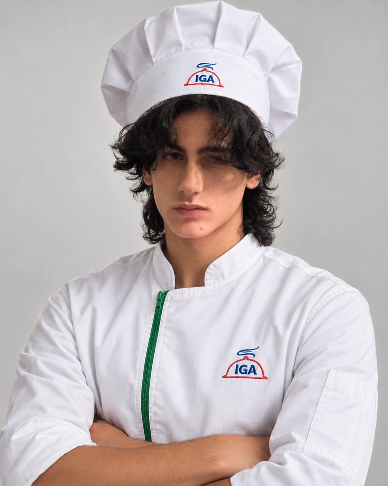 Felipe usando uniforme branco e toque de chef com identificação IGA.